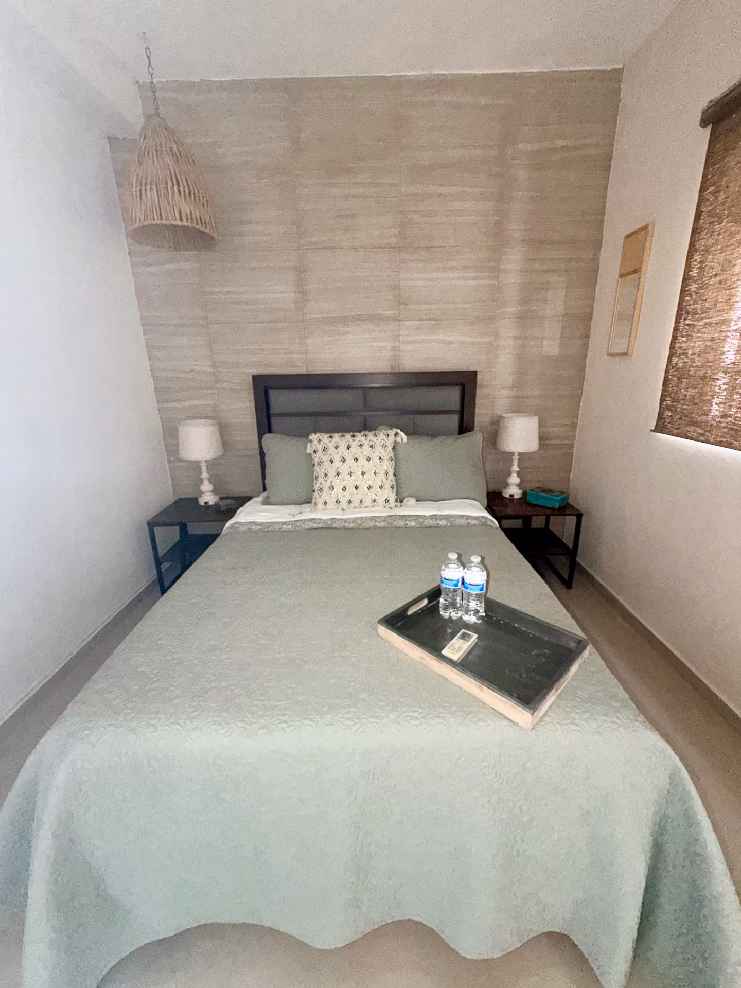 Bedroom with queen bed and welcome tray at a furnished stay in Guadalupe