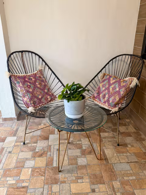 Outdoor lounge area with Acapulco chairs and a plant